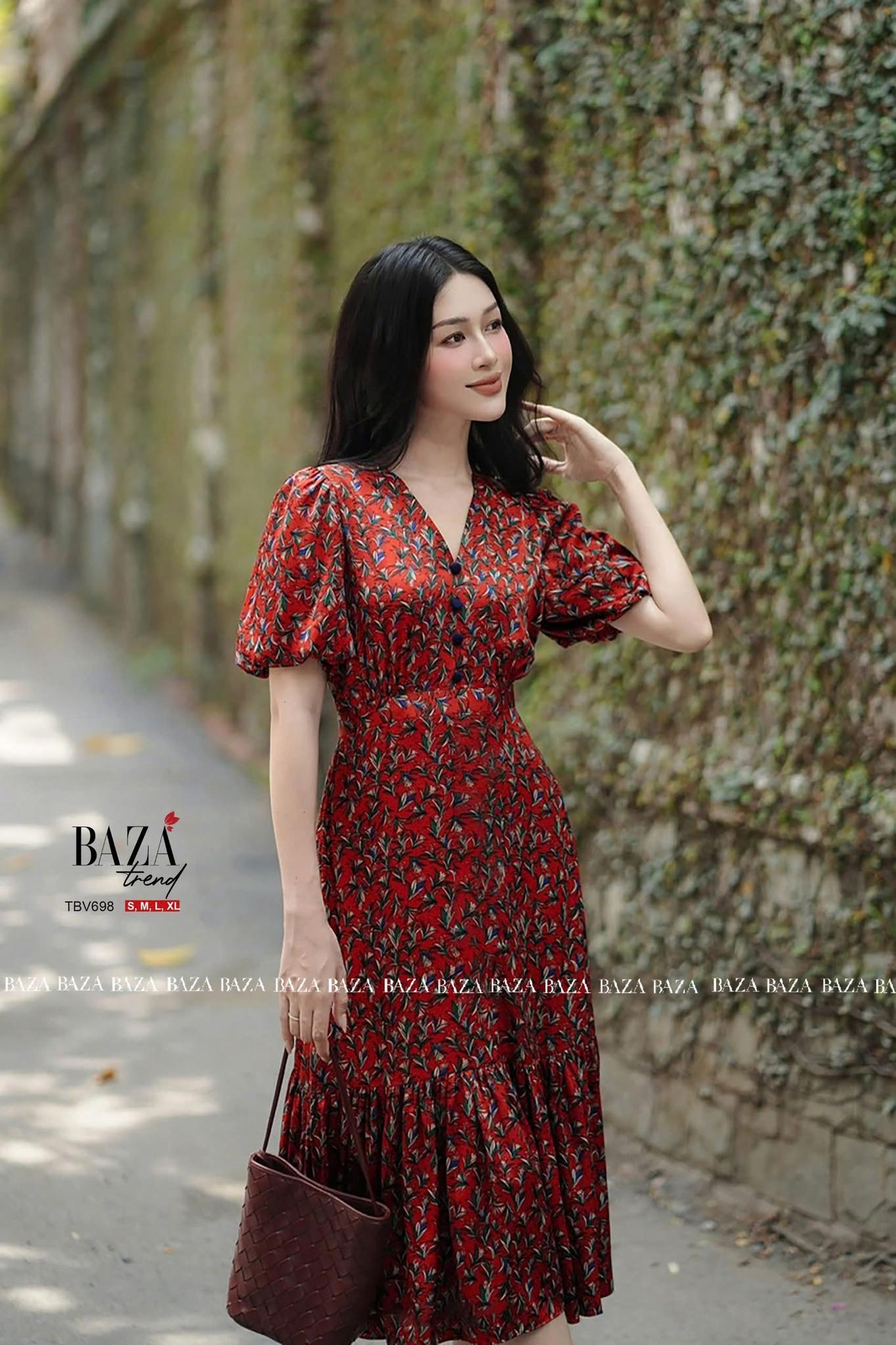 Đầm trung niên dáng dài nền đỏ họa tiết hoa đen, cổ chữ V và tay phồng nhẹ, tạo phong cách sang trọng và nữ tính.
